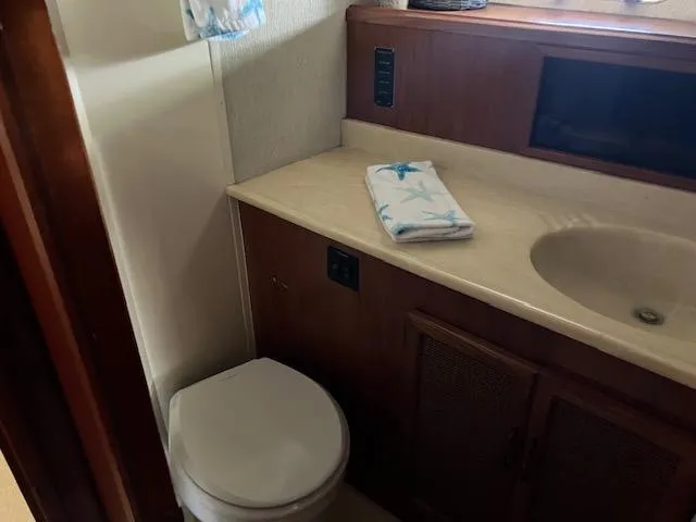 Slide: The Image of 1983 Viking Convertible yacht bathroom with sink, toilet, and wooden cabinetry. - 20