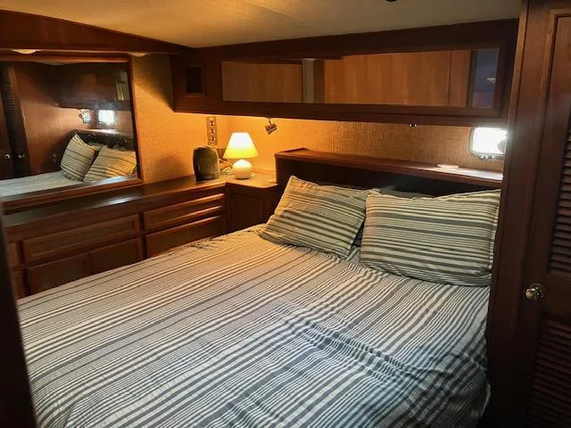 Slide: The Image of 1983 Viking Convertible bedroom with striped bedding, wooden cabinets, and ambient lighting. - 21