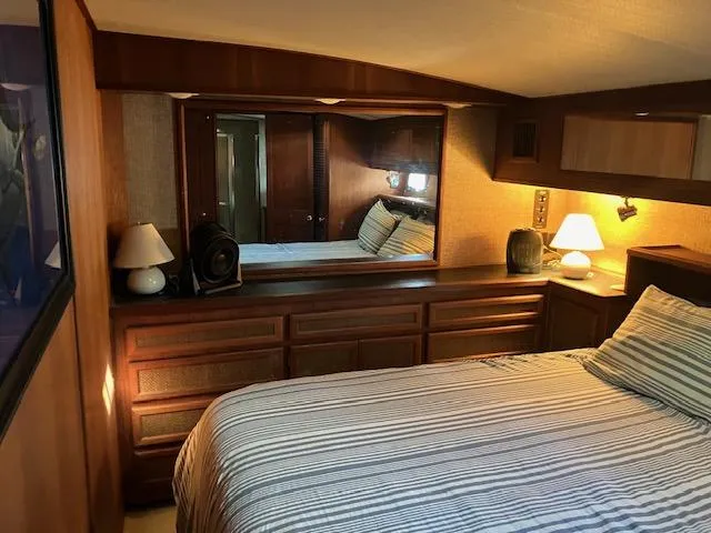 Slide: The Image of Cozy bedroom interior of a 1983 Viking Convertible yacht with striped bedding and wooden furnishings. - 22