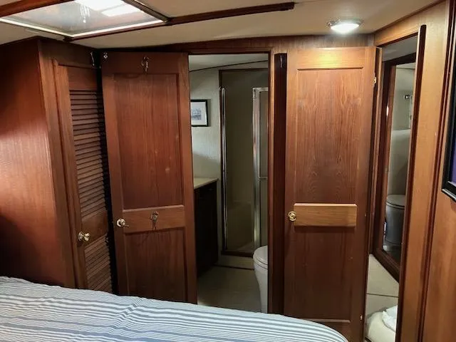Slide: The Image of 1983 Viking Convertible yacht interior with wooden cabinetry and bathroom view. - 23