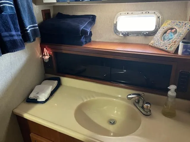 Slide: The Image of 1983 Viking Convertible bathroom with sink, towels, and porthole window. - 25