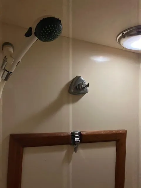 Slide: The Image of Shower area in a 1983 Viking Convertible boat, featuring a handheld showerhead. - 27