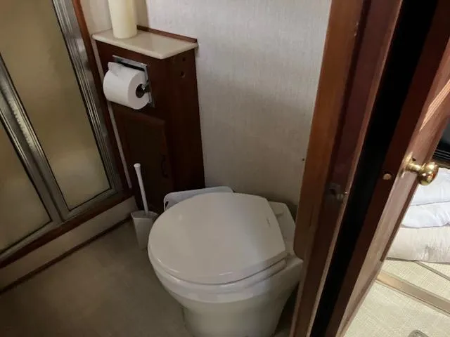 Slide: The Image of 1983 Viking Convertible bathroom with toilet, shower, and wooden accents. - 28