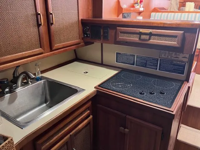 Slide: The Image of 1983 Viking Convertible yacht kitchen with sink, electric stove, and wooden cabinetry. - 31