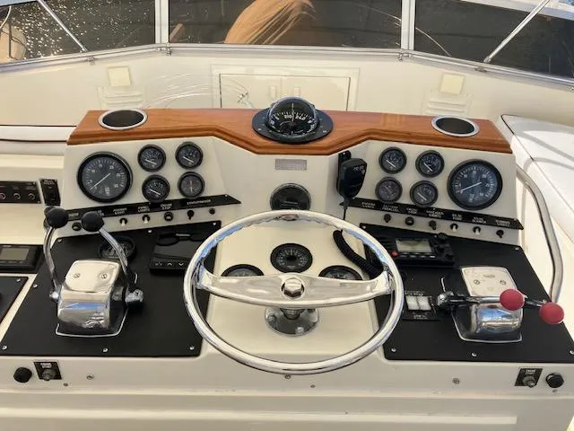 Slide: The Image of 1983 Viking Convertible boat dashboard with steering wheel, gauges, and controls. - 35