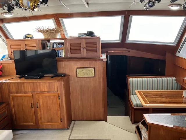 Slide: The Image of 1983 Viking Convertible yacht interior with wood cabinetry, TV, and striped seating area. - 4