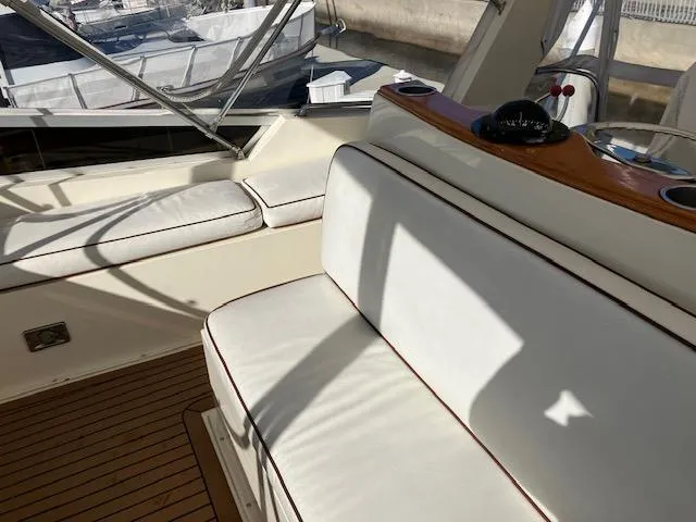 Slide: The Image of 1983 Viking Convertible boat interior with white seating and wooden accents. - 40