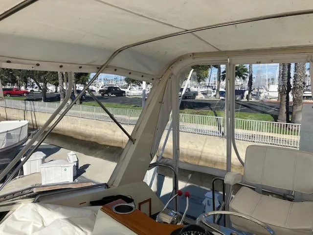 Slide: The Image of 1983 Viking Convertible boat interior with marina view, featuring helm and seating area. - 43