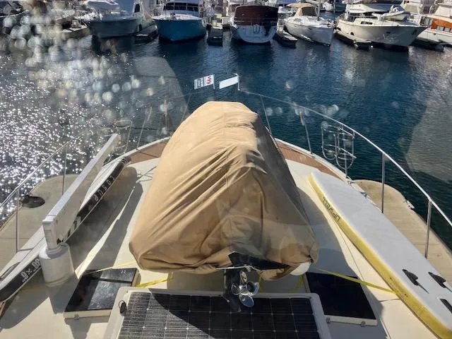 Slide: The Image of 1983 Viking Convertible yacht docked in marina, covered equipment on deck, surrounded by boats. - 44