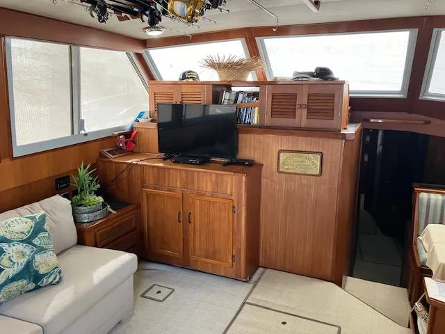 Slide: The Image of Interior of a 1983 Viking Convertible boat with wood paneling and cozy seating area. - 5