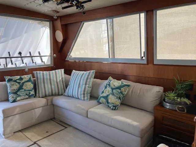 Slide: The Image of 1983 Viking Convertible yacht interior with cozy seating and nautical-themed cushions. - 8