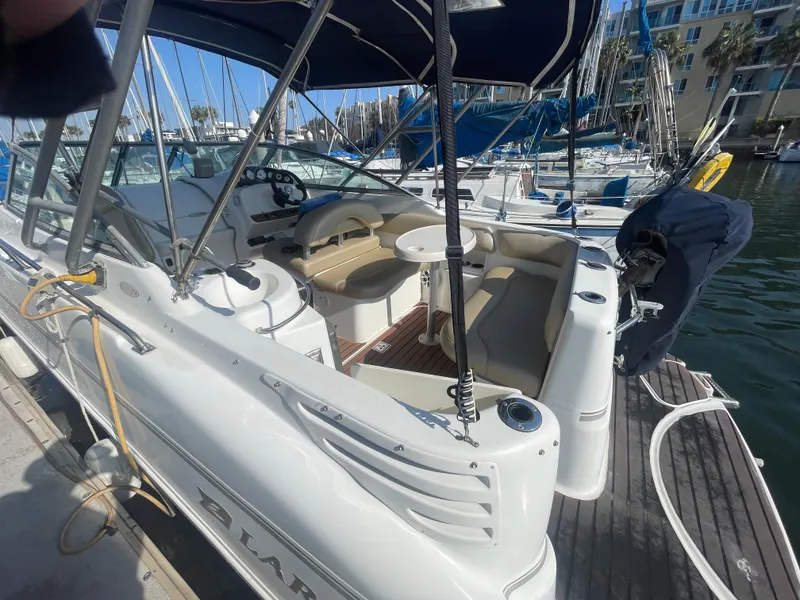 Slide: The Image of 2003 Larson 270 boat docked, featuring spacious seating and canopy. - 2