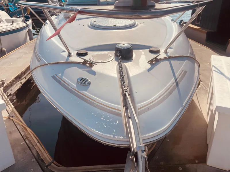 Slide: The Image of 2003 Larson 270 boat docked, showcasing its sleek bow design and stainless steel railings. - 3