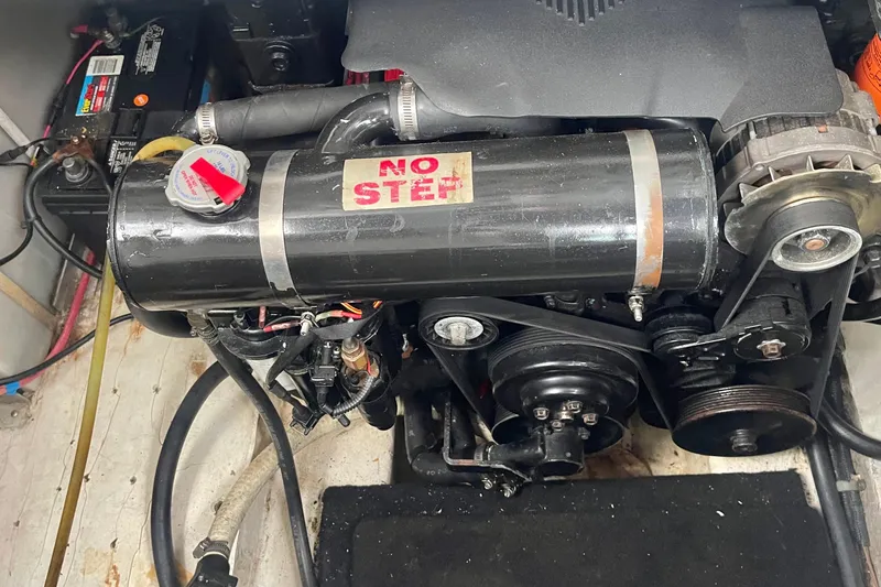 Slide: The Image of Engine compartment of a 2003 Larson 270 boat with visible components and "No Step" label. - 31