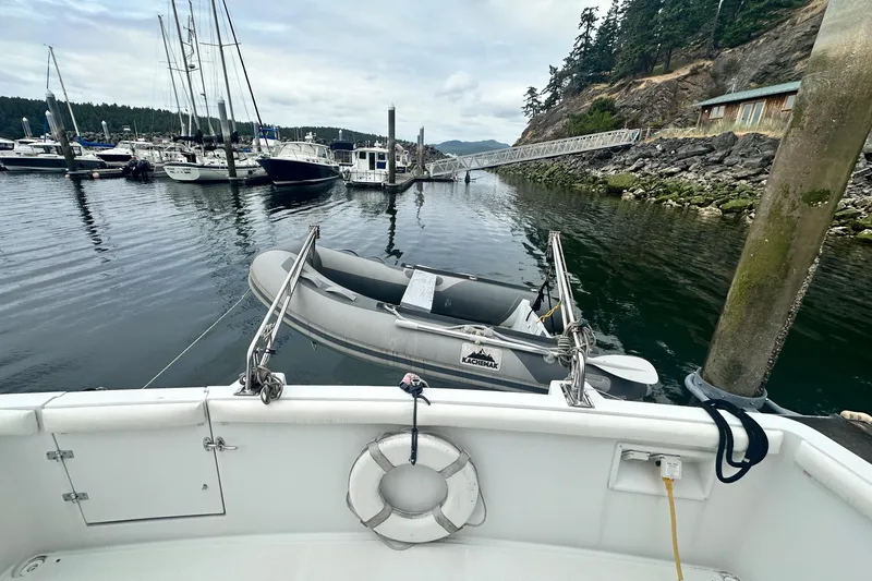 Slide: The Image of 2000 Carver 374 Voyager docked in a scenic marina with surrounding boats and lush greenery. - 12