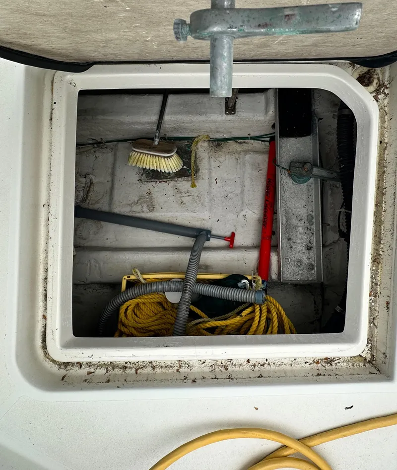 Slide: The Image of Storage compartment on a 2000 Carver 374 Voyager boat with cleaning tools and ropes. - 16