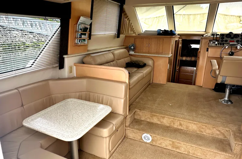 Slide: The Image of Interior of 2000 Carver 374 Voyager yacht with beige seating and dining area. - 26