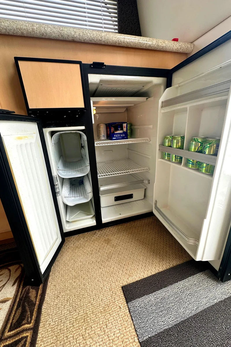 Slide: The Image of Open refrigerator inside a 2000 Carver 374 Voyager yacht, stocked with beverages. - 32
