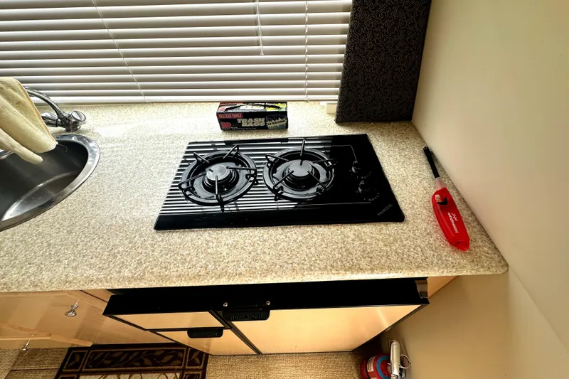 Slide: The Image of Compact kitchen in 2000 Carver 374 Voyager with stove, sink, and lighter. - 33