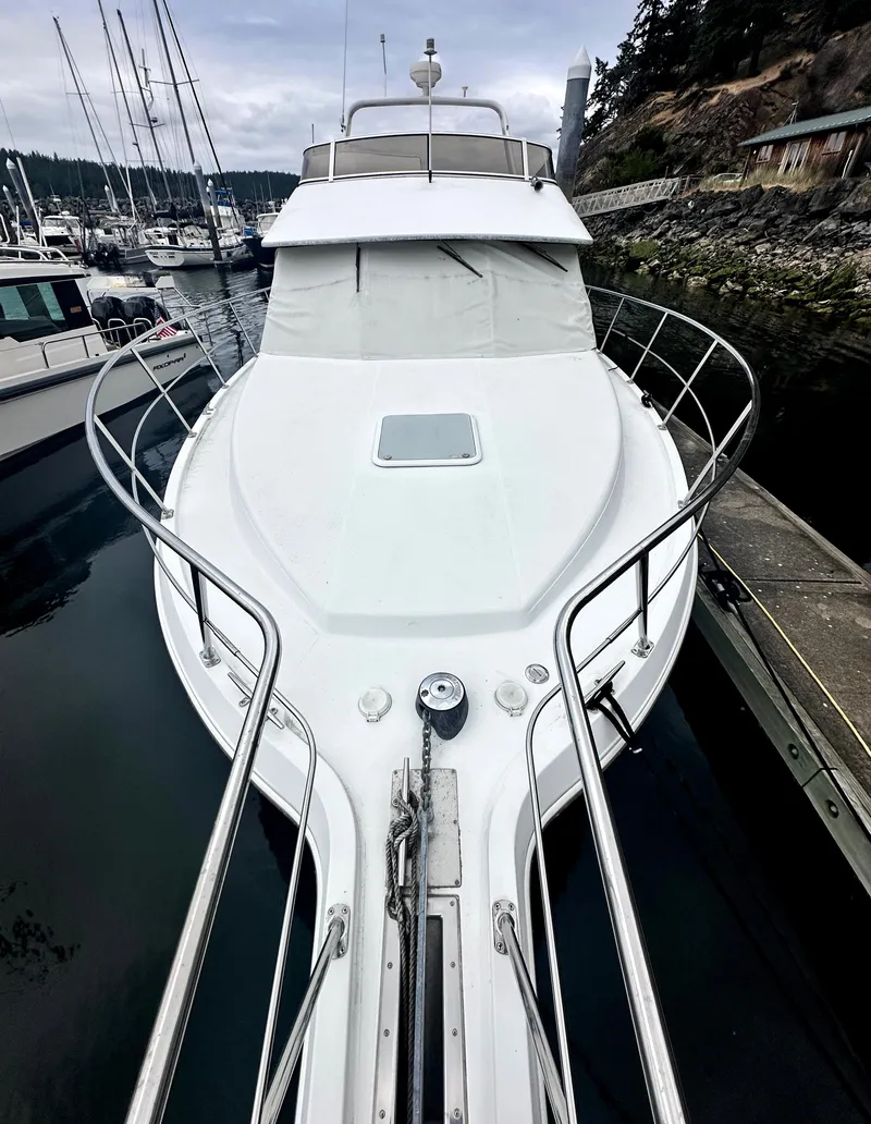 Slide: The Image of 2000 Carver 374 Voyager yacht docked at a marina, showcasing sleek design and spacious deck. - 4
