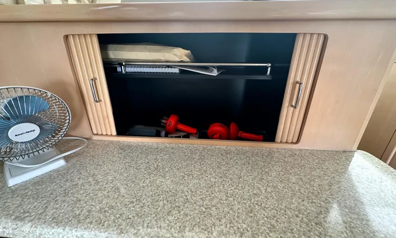 Slide: The Image of Cabinet interior on 2000 Carver 374 Voyager yacht with fan and tools. - 48