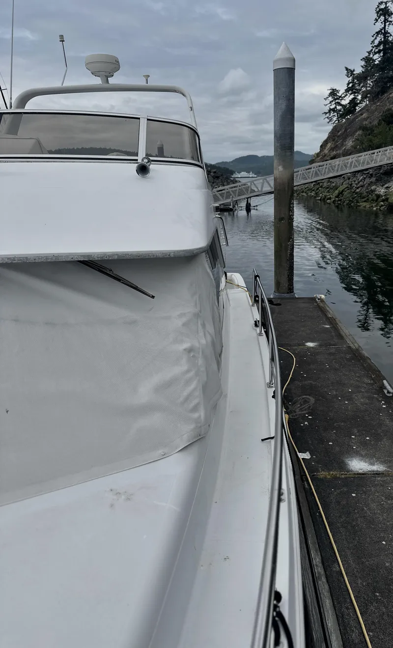 Slide: The Image of 2000 Carver 374 Voyager yacht docked by a calm waterfront. - 6