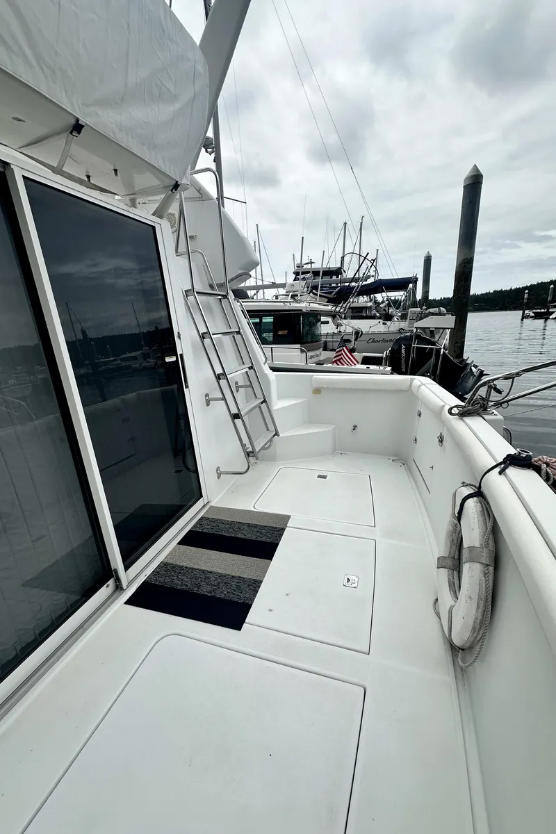 Slide: The Image of 2000 Carver 374 Voyager yacht deck with ladder and marina view. - 8