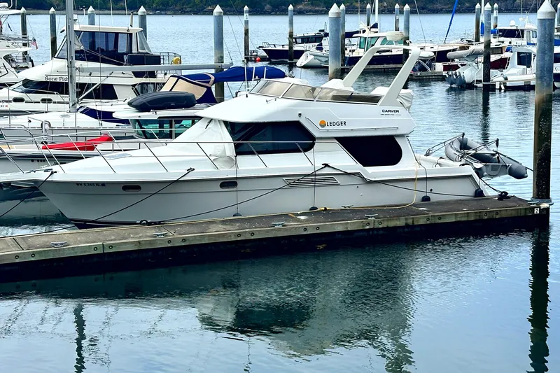 The Image of 2000 Carver 374 Voyager yacht docked at a marina, surrounded by other boats. - 0
