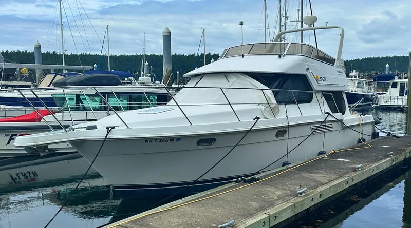 Slide: The Image of 2000 Carver 374 Voyager yacht docked at a marina, surrounded by other boats. - 1