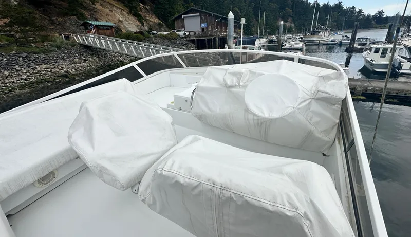 Slide: The Image of 2000 Carver 374 Voyager yacht deck with covered seating, docked at a marina. - 19