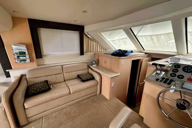 Slide: The Image of Interior of 2000 Carver 374 Voyager yacht with beige seating and helm controls. - 38