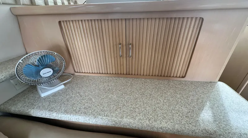 Slide: The Image of 2000 Carver 374 Voyager interior with countertop, cabinet, and small fan. - 47