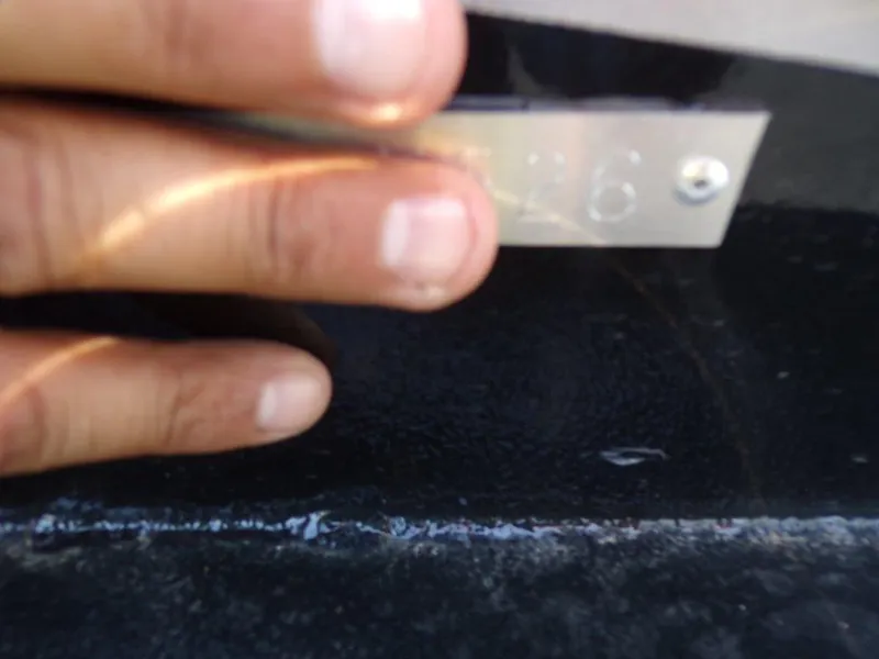 Slide: The Image of Close-up of a hand holding a metal plate on a 2026 Xpress SW20BAY boat. - 16