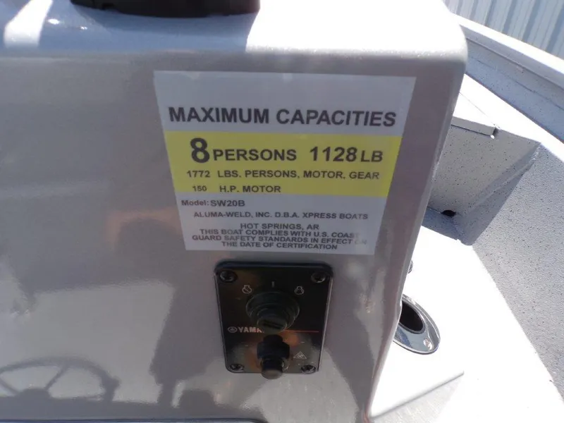 Slide: The Image of 2026 Xpress SW20BAY boat capacity label, maximum 8 persons, 1128 lbs, 150 HP motor. - 2