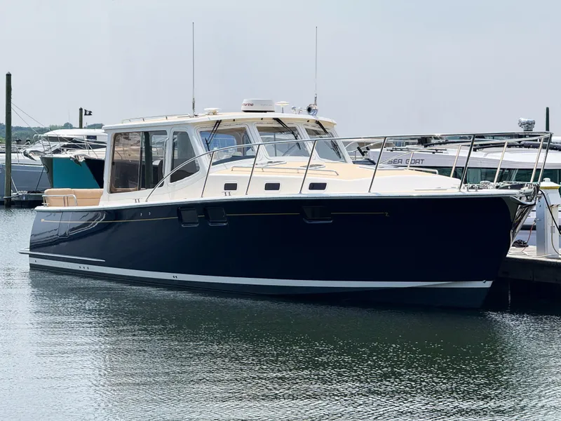 Slide: The Image of 2017 MJM 40z Downeast yacht docked in marina, sleek design, calm water reflection. - 0