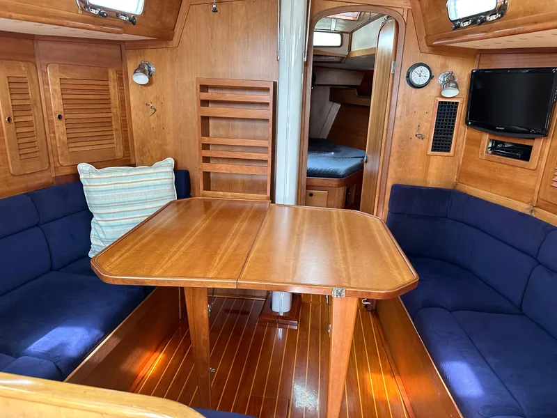 Slide: The Image of Interior of 1994 Sabre 425 sailboat with wooden table and blue seating. - 10