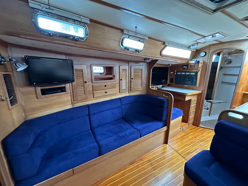 Slide: The Image of Interior of 1994 Sabre 425 yacht with blue seating, wood paneling, and mounted TV. - 13
