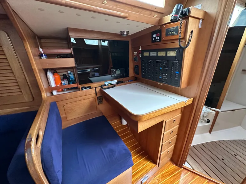 Slide: The Image of Navigation station inside 1994 Sabre SABRE 425 sailboat with wooden cabinetry and blue seating. - 14