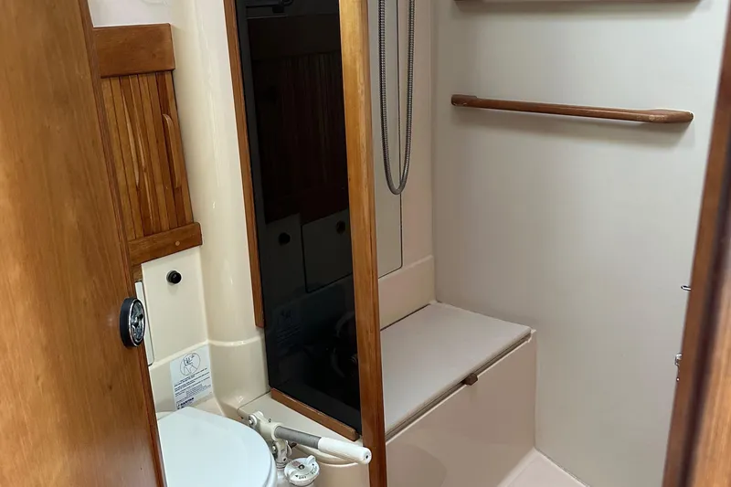 Slide: The Image of Bathroom interior of 1994 Sabre SABRE 425 yacht, featuring wooden accents and compact design. - 16