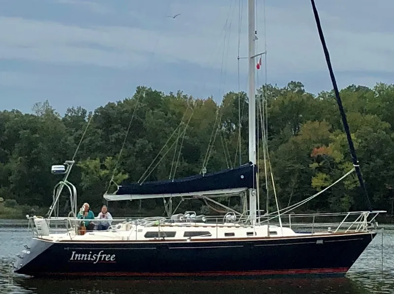 Slide: The Image of Sailing yacht Sabre 425, 1994 model, named "Innisfree" on calm water with forest backdrop. - 17