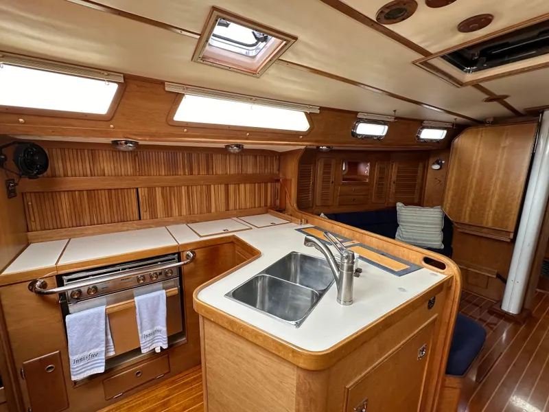 Slide: The Image of 1994 Sabre SABRE 425 yacht interior with wooden cabinetry, kitchen sink, and oven. - 21