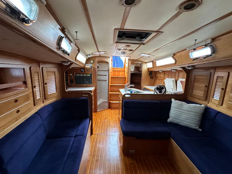 Slide: The Image of Interior of 1994 Sabre SABRE 425 sailboat with wooden finish and blue seating. - 7