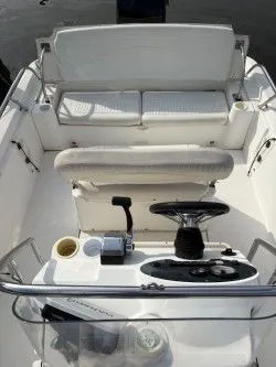 Slide: The Image of 2002 Boston Whaler DAUNTLESS boat interior with steering wheel and seating. - 2