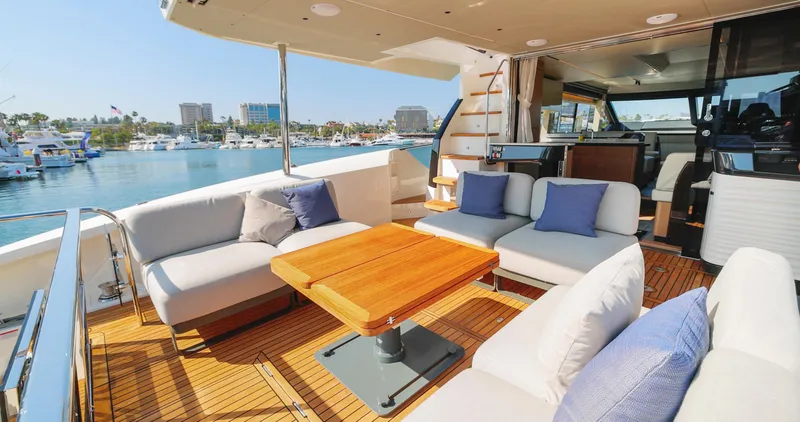 Slide: The Image of Luxurious 2024 Absolute 60 Fly yacht with spacious outdoor seating and scenic marina view. - 22