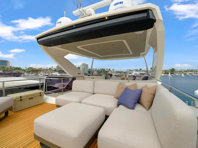 Slide: The Image of Luxurious 2024 Absolute 60 Fly yacht with spacious outdoor seating and scenic marina view. - 9