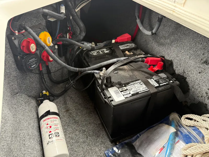 Slide: The Image of 2016 Yamaha 242 Limited S E-Series boat battery compartment with fire extinguisher and wiring. - 24