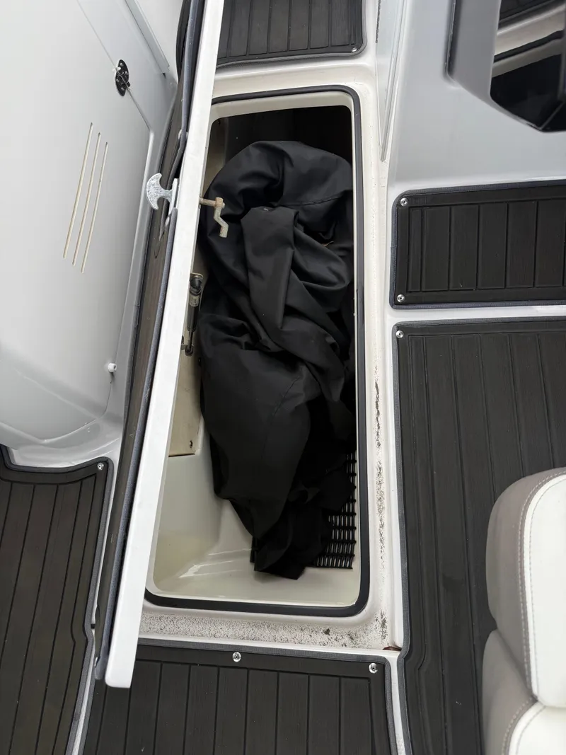 Slide: The Image of 2016 Yamaha Boats 242 Limited S E-Series storage compartment with black cover inside. - 40
