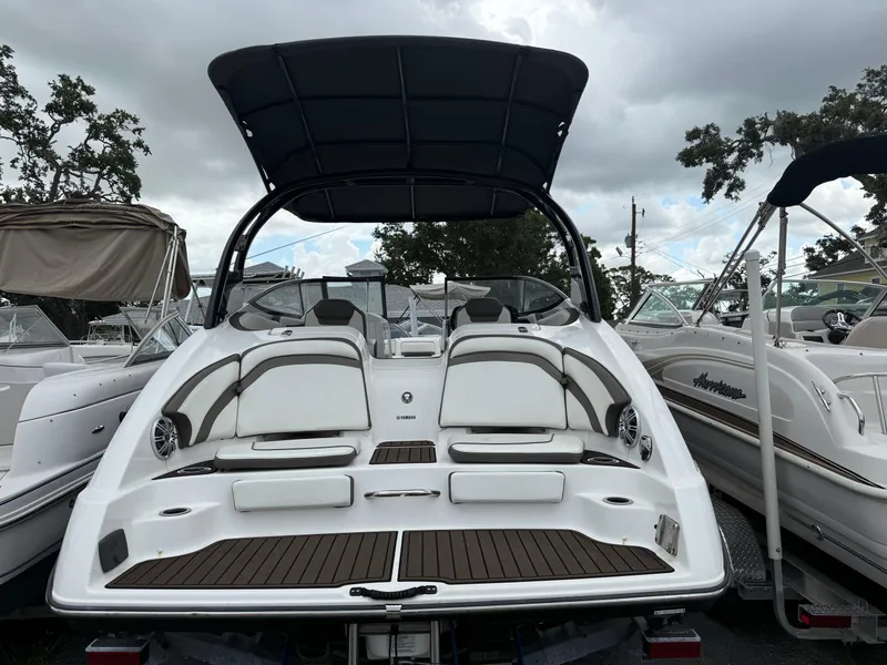 Slide: The Image of 2016 Yamaha Boats 242 Limited S E-Series, rear view, docked with canopy, surrounded by other boats. - 6