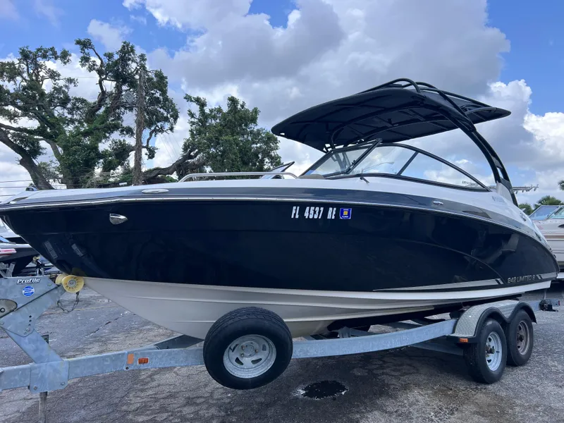 Slide: The Image of 2016 Yamaha Boats 242 Limited S E-Series on trailer, parked outdoors under cloudy sky. - 1