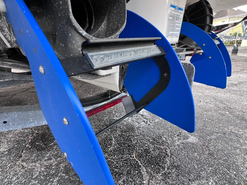 Slide: The Image of Close-up of 2016 Yamaha 242 Limited S E-Series boat's blue rudder system on pavement. - 9